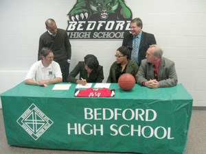 Family, coaches and administrators watch as Bedford High's Ciara Herring signs with the University of Rio Grande